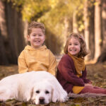 Kinder mit Hund im Herbstlaub